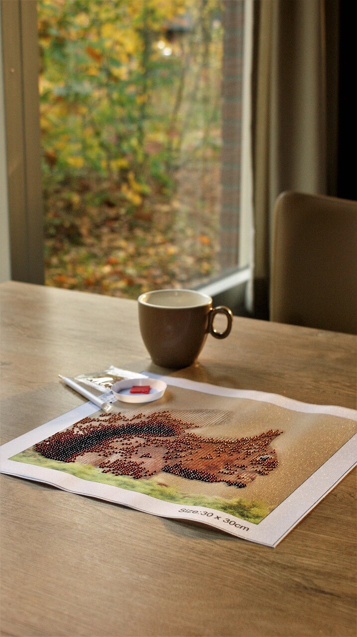 A relaxing diamond painting project beside a cup of tea